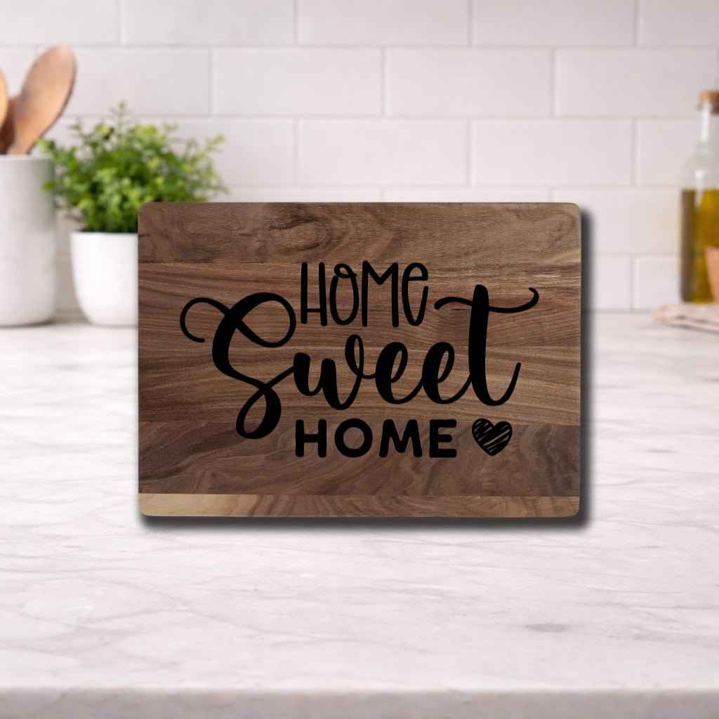 Elegant cutting boards with custom engraving featuring a 'Home Sweet Home' design on a kitchen countertop.
